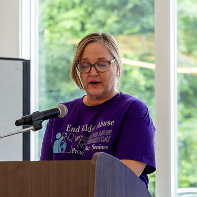 An older adult leads a group of participants holding signs during an elder abuse awareness march in Brockton.